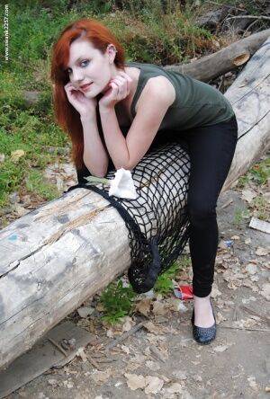 Young redhead chick Nicci Vice showing off tits and ass in the woods on pornstar6.com