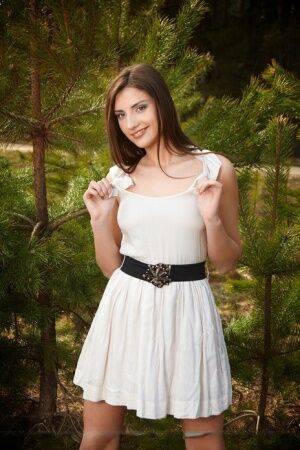 Nice teen Alisee D stands naked in the woods after removing white dress on pornstar6.com