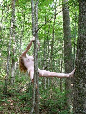 Natural redhead Nicki Blue swings from a tree while totally naked in the woods on pornstar6.com