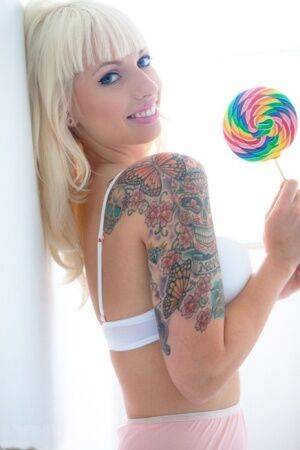 Tattooed blonde Lynn Pops strikes great poses with a lollipop in hand on pornstar6.com