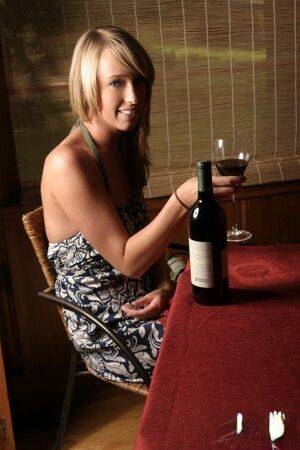 Blonde amateur Daisy bares small firm tits while enjoying a glass of wine on pornstar6.com