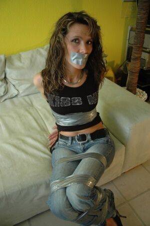 Clothed female is silenced and restrained with duct tape on a sofa on pornstar6.com