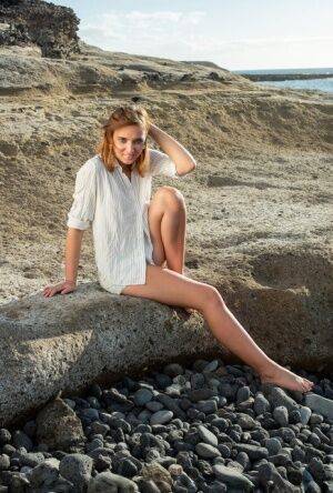 Pretty teen Oxana Chic disrobes for a nude modelling gig on a beach on pornstar6.com