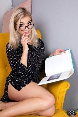 Geeky blonde Amelia undresses on a chair before playing with her shaved pussy on pornstar6.com