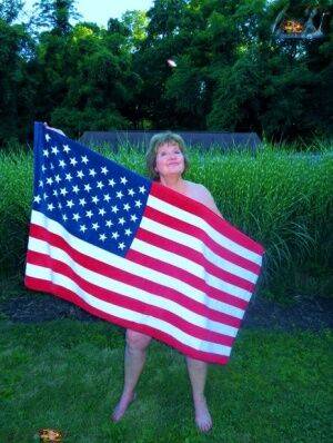 Older plumper Busty Bliss holds an American flag while totally naked in a yard - Usa on pornstar6.com