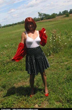 Older redhead Lauren models a retro girdle and nylons in a field on pornstar6.com