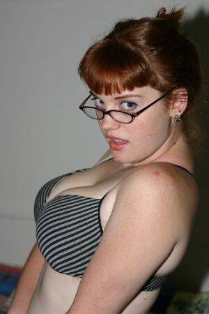 Redhead amateur Sawyer cups her natural breasts before removing her glasses on pornstar6.com