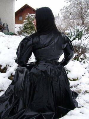 Goth woman Lady Angelina models a black latex dress on snow-covered ground on pornstar6.com