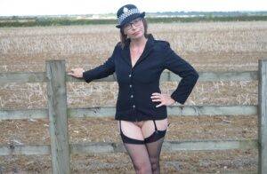 Mature policewoman Barby Slut removes her uniform against a fence at a farm on pornstar6.com