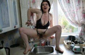 Amateur woman Juicey Janey squats over the kitchen sink for a piss on pornstar6.com