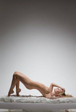 Beautiful blonde Gabi hits upon great nude poses on a hunk of fabric on pornstar6.com