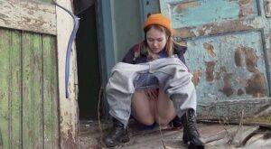 Cute girl pulls down jeans for an urgent piss on the steps of an old building on pornstar6.com