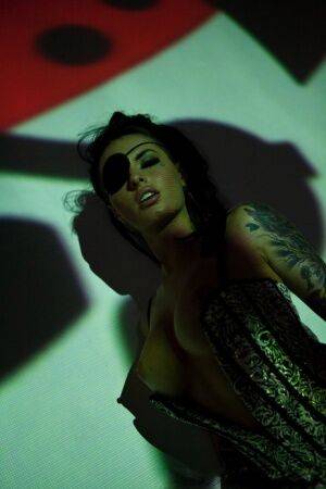 Solo girl Christy Mack wears an eye patch and lingerie while posing in shadows on pornstar6.com