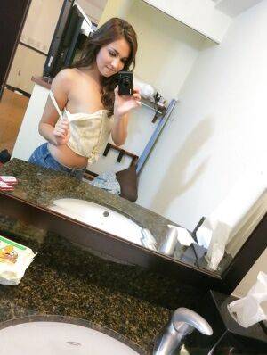 Sassy brunette stripping in front of the mirror and making selfies on pornstar6.com