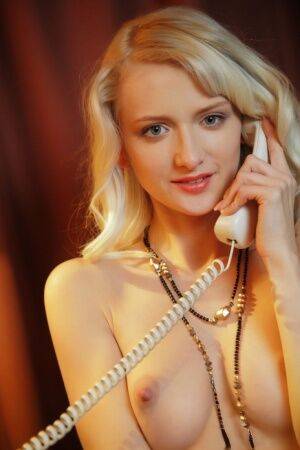 Sweet blonde teen Nika N answers the telephone while wearing a garter belt on pornstar6.com