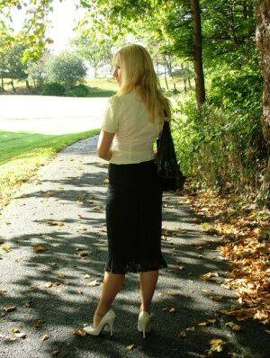 Clothed blonde Iona shows off her white stilettos in a long skirt by a park on pornstar6.com