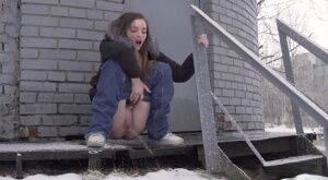 White girl pulls down her jeans to pee in the snow behind a building on pornstar6.com