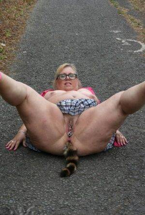 Fat UKwoman Lexie Cummings walks a path sporting a raccoon tail butt plug on pornstar6.com