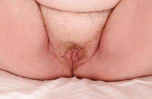 Mature plumper with huge saggy jugs and hairy cooter posing on the bed on pornstar6.com