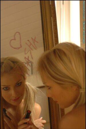 Gorgeous blonde Natasha Marley goes topless in front of a mirror on pornstar6.com