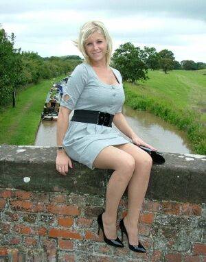 Blonde female sits atop a bridge in a dress and nylons with shiny pumps on pornstar6.com