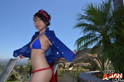 Luscious oriental youthful May Lee in beautiful bikini exposing tiny tits and spreading her legs at pool on pornstar6.com